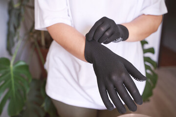 The hand wearing a rubber glove. Symbolizing safety in work. It conveys approval and positive communication. Satisfaction and protection. Putting on hand
