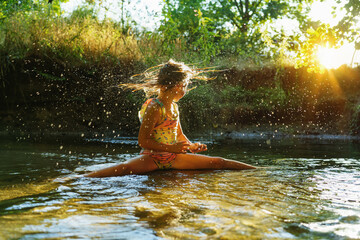  little girl playing in the river. A girl with blond hair in a sunbeam surrounded by thousands of small drops.