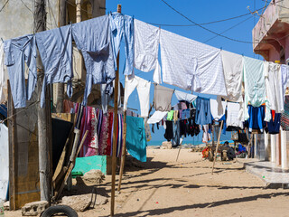 du linge sèche suspendu à une corde dans une rue de la vieille ville de Saint louis du Sénégal en Afrique - obrazy, fototapety, plakaty