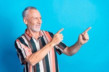 Photo of handsome satisfied retired man wear striped trendy clothes look empty space isolated on blue color background