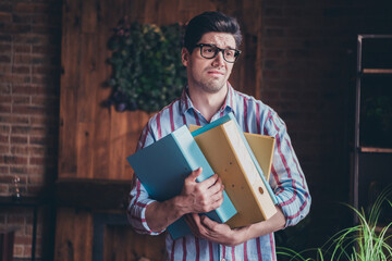 Photo of nice young corporate man hold folders think wear striped shirt loft interior office indoors