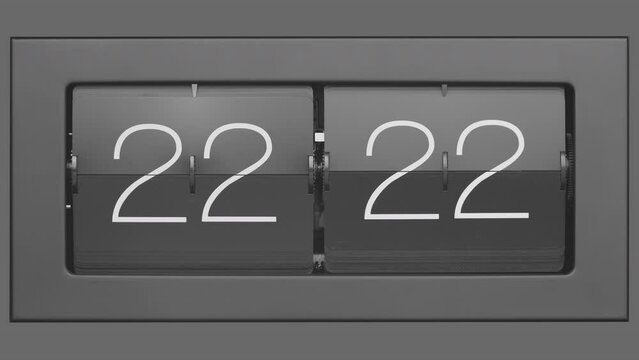 Flip clock quickly flips. Retro flip clock changing from 22:21 to 22:22. Slow motion. Close up. 