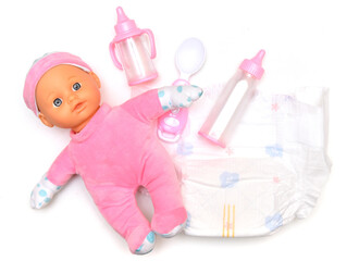 Baby doll, diapers, pacifier and bottles for feeding a baby on a white background. Taking care of...