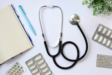Stethoscope, notepad and pen on a light background, top view. Cardiology and healthcare concept....