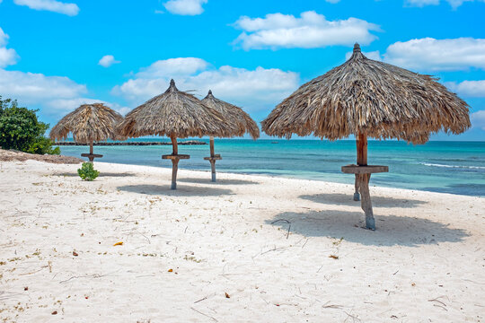 Straw umbrellas on Eagle Beach, Aruba on a lovely summer day.