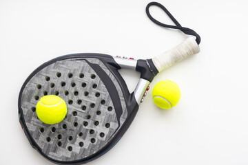Set of paddle tennis rackets and balls the reflected on white table and white isolated background. Front view.