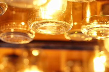 Vintage glass jars on the ceiling in the store in the evening. Light through the glass of the jar	
