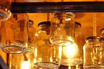 	
Vintage glass jars on the ceiling in the store in the evening. Light through the glass of the jar	
