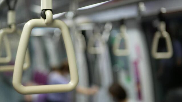 Close up view with selective focus of a looped handle handrails hold in subway train commuter urban public transportation.empty interior of a city subway train