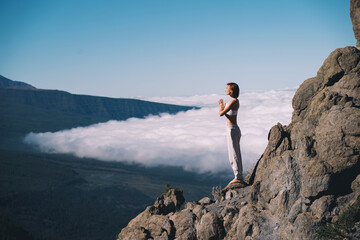 Woman doing yoga and meditating on background of natural landscape