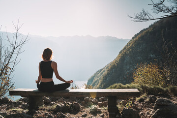 Young woman is meditating in mountains. - 789345016