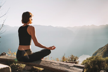 Young woman is meditating in mountains.