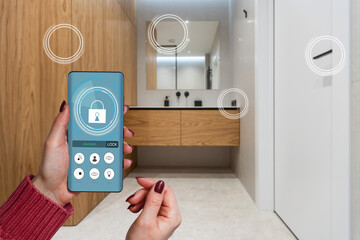 Smart home automation app on smartphone hold by female hand with home interior in background - 789347665