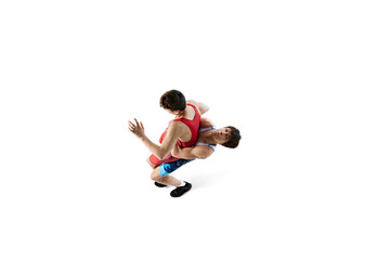 Top view. Wrestlers in action, two male athletes wrestling, training isolated on white background. Concept of combat sport, martial arts, competition, tournament, athleticism