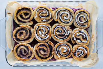 Top down view of blueberry cinnamon buns with some frosted with icing.