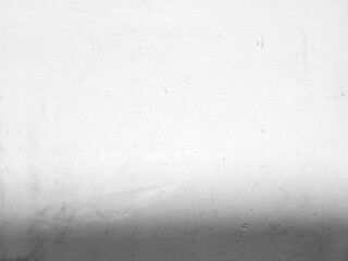 White grunge concrete wall background with light beam on surface and shadow at the bottom.