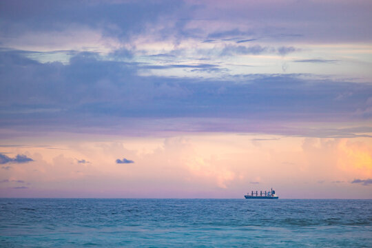 Cargo ship lined up at sea on it's way to Newcastle Harbour under a vibrant sunset sky