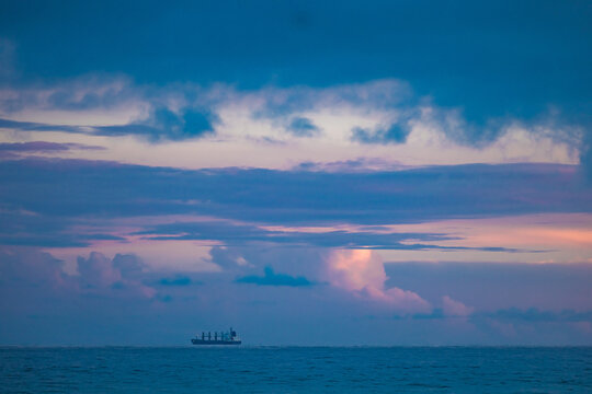 Cargo ship lined up at sea on their way to Newcastle Harbour under a vibrant sunset sky