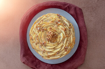 Homemade apple and walnut pie Charlotte on plate with fresh apples, cinnamon and walnuts Homemade autumn desserts