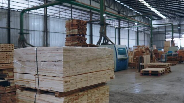 Industrial woodworking facility with machinery and lumber stacks.