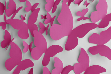 Bright pink paper butterflies on white wall