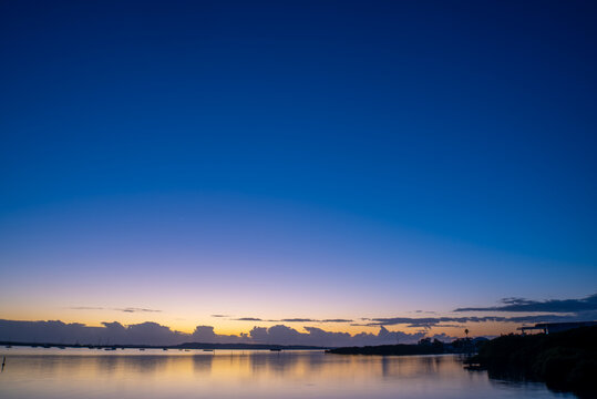 Dawn sky over water with clouds