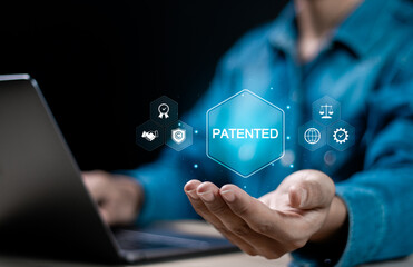 Patented patent copyright law business technology concept. businessman using laptop with patented word with copyright icons for author rights and patented intellectual property.
