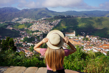 Tourism in Ouro Preto, Brazil. Back view of young traveler woman enjoying lookout of Ouro Preto historical city UNESCO world heritage site in Minas Gerais state, Brazil.