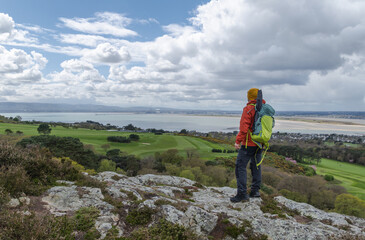 Adventurous hiker man in mountain top, enjoying Dublin bay landscape