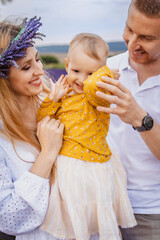 An active family in a lavender field with a mom and dad with their little daughter
