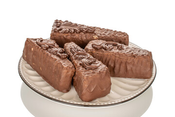 Several pieces of chocolate waffle cake on a ceramic saucer, macro, isolated on white background.