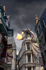 Obraz premium Universal Studio Orlando. , Harry Potter world, the dragon above Gringotts bank in Diagon Alley breathes fire and smoke with a moody sky. Theme park in the United States. 