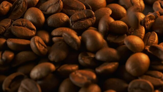 Falling coffee beans pile macro close up background. Aromatic caffeine. Copy space.