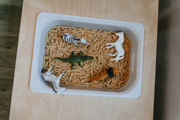 Plastic containers with pasta for developing tactility in children in kindergarten