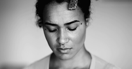 One anxious young black woman close-up face expressing preoccupation and mental despair in dramatic...