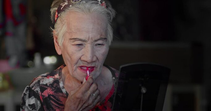 Asian woman who is an elderly person with a good mood who love to put on makeup and dress up all the time.