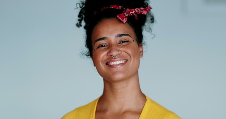 One happy young black Brazilian woman smiling with friendly demanor. Close-up face of a joyful 20s...