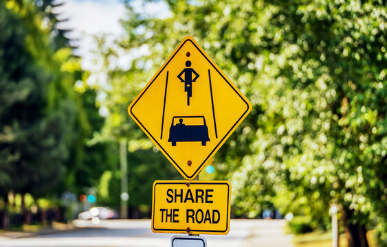 Share the road, yellow warning traffic sign in Canada