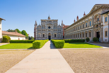 Panorama view of Certosa di Pavia monastery,historical monumental complex that includes a monastery and a sanctuary and green court.The Ducale Palace on the right,Pavia,Italy. - obrazy, fototapety, plakaty