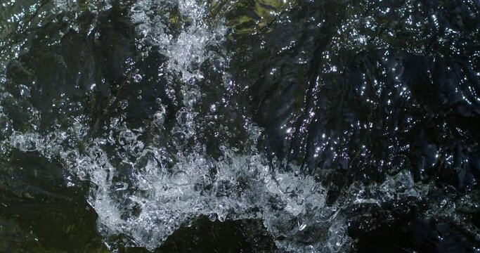 Super slow motion of crystal clear pure water bubbles flowing stream on fresh natural liquid surface background. Filmed on high speed cinema camera at 1000 fps.