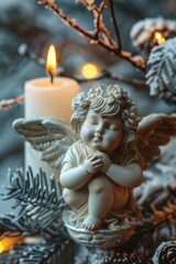 Fototapeta premium A small angel figurine sitting next to a lit candle. Ideal for religious or spiritual concepts