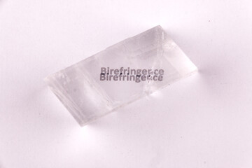 Optical birefringence demonstrated using a text using a natural double spar / calcite crystal
