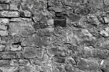 in the photo there is an old gray stone wall close up