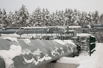pipelines in winter against the backdrop of a snow-covered forest