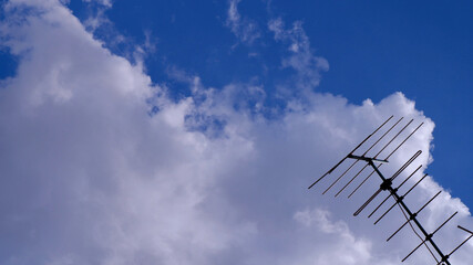 TV antenna or external television with a bright blue sky as a background. Beautiful clouds and sky...