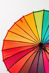Bright rainbow colored umbrella against a clear white sky. Perfect for adding a pop of color to any design project
