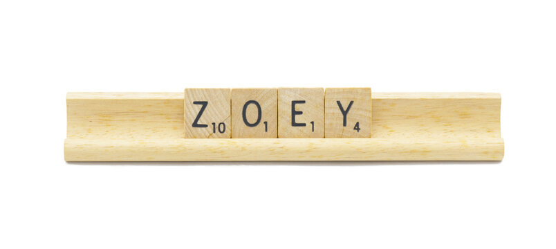 Miami, FL 4-18-24 popular baby girl first name of ZOEY made with square wooden tile English alphabet letters with natural color and grain on a wood rack holder isolated on white background
