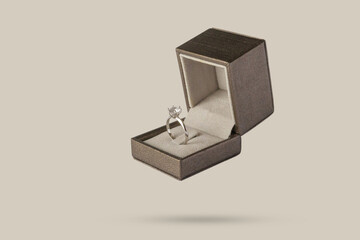 Diamond ring in jewelry gift box floated on brown background - 789473077