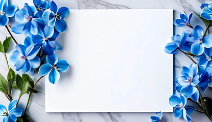 Beautiful work decorated with a blank page and blue flowers on a white marble top view. Copy-space, place for your lettering. 