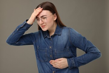 Woman having heart attack on grey background